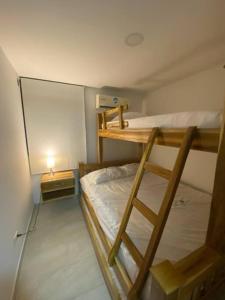 a bedroom with two bunk beds and a lamp at Apto cerca al mar amoblado. in Coveñas