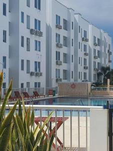 een groot appartementencomplex met een zwembad ervoor bij Apto cerca al mar amoblado. in Coveñas