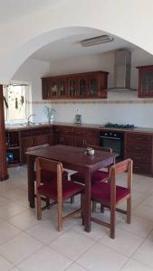 a kitchen with a wooden table and two chairs at Casa Sofia in Mindelo +19 photos