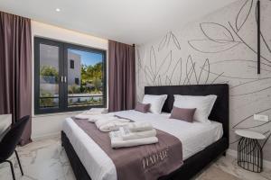 a bedroom with a bed with towels on it at HADRIE LUXURY RESORT AND VILLAS ROVA ed in Vantačići