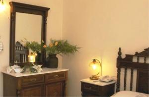a bedroom with a dresser with a mirror and a bed at Aegeon Hotel in Karlovasi