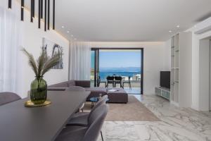 a living room with a table and chairs at HADRIE LUXURY RESORT AND VILLAS ROVA ed in Vantačići
