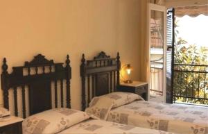 two beds sitting next to each other in a bedroom at Aegeon Hotel in Karlovasi