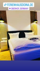 1 dormitorio con 1 cama con sábanas azules y blancas en Ferienhaus Doina, en Gehlberg