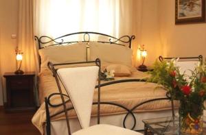 a bedroom with a bed with two lamps and flowers at Aegeon Hotel in Karlovasi