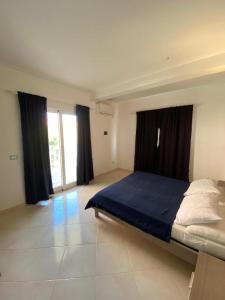 een slaapkamer met een bed met blauwe lakens en ramen bij Estrela do Mar in Santa Maria