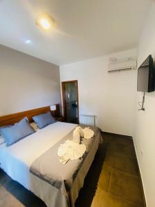 1 dormitorio con 1 cama con toallas en Ranqueles en Villa Carlos Paz