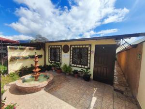 a house with a fountain in front of a building at Aires frescos de Boquete in Alto Boquete