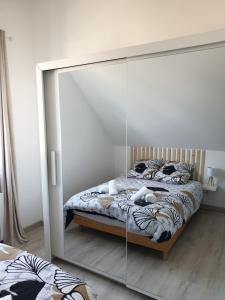 - un miroir réfléchissant le lit dans la chambre dans l'établissement Plume - Dormir Comme A La Maison, à Guérande