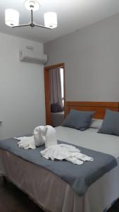 a bedroom with two beds with towels on the bed at Ranqueles in Villa Carlos Paz