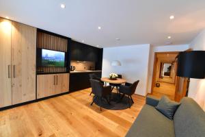 a living room with a couch and a table with chairs at Ferienwohnungen Kohler komplett neu renoviert E-Ladestaion kostenlos in Mittelberg +26 photos