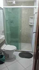 uma casa de banho com um WC e uma cabina de duche em vidro. em Casa da Praia em Costazul em Rio das Ostras