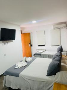 a room with two beds and a flat screen tv at Ranqueles in Villa Carlos Paz