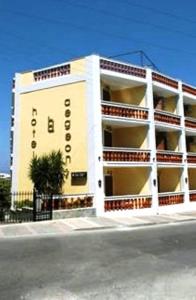 a white building with a sign on the side of it at Aegeon Hotel in Karlovasi