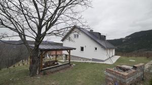 een wit huis met een boom in de tuin bij Apartman Trebevic-Sarajevo in Dovlići