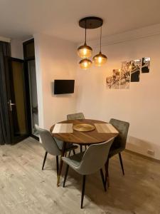 a dining room with a wooden table and chairs at RR Residence in Craiova +2 photos