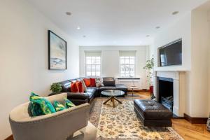 uma sala de estar com um sofá e uma lareira em Colourful South Kensington Home em Londres