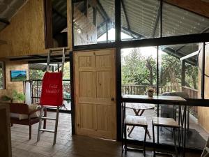 a room with a door and a chair and a table at Bonita cabaña estilo glamping in Juayúa