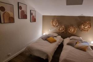 2 camas en un dormitorio con espejos en la pared en Gite le 159 avec sauna et jacuzzi, en Vesseaux