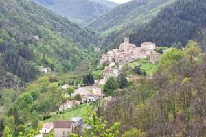 un petit village au milieu d'une montagne dans l'établissement Gite le 159 avec sauna et jacuzzi, à Vesseaux