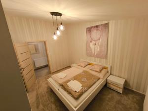 a bedroom with a bed and a painting on the wall at ApartmanyHurbanova2 in Bardejov