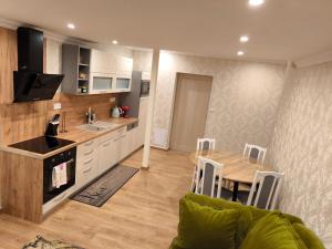 a kitchen and dining room with a table and a couch at ApartmanyHurbanova2 in Bardejov