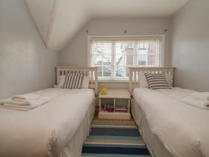 two beds in a small room with a window at 6 The Whinlands in Leiston