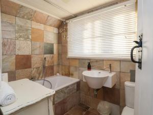 a bathroom with a sink and a tub and a toilet at 6 The Whinlands in Leiston +18 photos