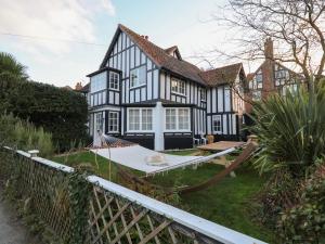 a black and white house with a hammock in the yard at 6 The Whinlands in Leiston