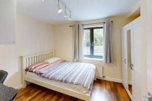 1 dormitorio con cama y ventana en Lovely two bed flat with free parking (4 117) en Nottingham