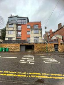 een lege straat met een gebouw op de achtergrond bij Lovely two bed flat with free parking (4 117) in Nottingham