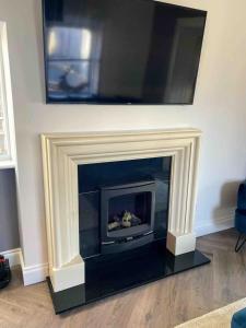 a fireplace with a tv above it in a living room at Stanley Place in Greystones