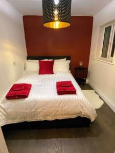 a bedroom with a bed with two red pillows on it at Stanley Place in Na Clocha Liatha