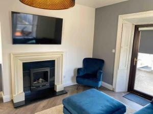 uma sala de estar com uma cadeira azul e uma lareira em Stanley Place em Na Clocha Liatha