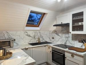 a kitchen with white cabinets and a sink and a window at Boann 5 - Hot Tub-Hunting Tower Lodges-Luxury-Families-Romantic in Perth