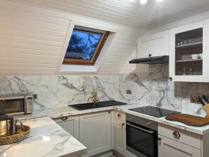 a kitchen with white cabinets and a sink and a window at Boann 5 - Hot Tub-Hunting Tower Lodges-Luxury-Families-Romantic in Perth +9 photos
