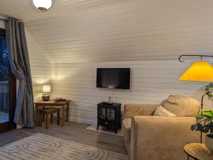 a living room with a couch and a flat screen tv at Boann 5 - Hot Tub-Hunting Tower Lodges-Luxury-Families-Romantic in Perth