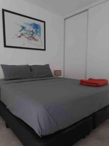 a large bed with a red blanket on top of it at Excelente departamento en pleno centro in Puerto Iguazú +7 photos