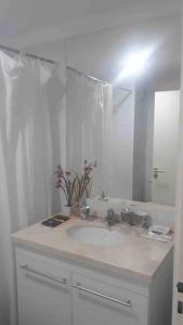 a white bathroom with a sink and a mirror at Excelente departamento en pleno centro in Puerto Iguazú