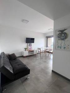 a living room with a black leather couch and a table at Excelente departamento en pleno centro in Puerto Iguazú