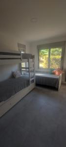 1 dormitorio con 2 literas y ventana en Alfonsina Holiday Home en Sierra de la Ventana