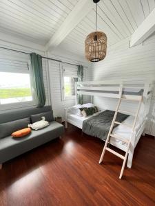 a bedroom with a bunk bed and a couch at Superbe Villa Bwa Lélé in Rivière-Salée