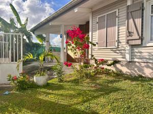 ein Haus mit Blumen an der Vorderseite in der Unterkunft Superbe Villa Bwa Lélé in Rivière-Salée