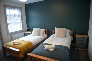 a bedroom with two beds and a window at The Limes - Stylish City Centre Retreat in Peterborough