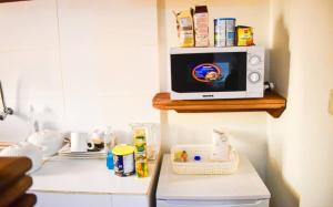 un four micro-ondes installé au-dessus d'un comptoir de cuisine dans l'établissement 6 Appartements/ 6 studios privé à Bangui RESIDENCE RENESSIOT, à Bangui