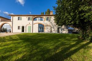 a large house with a green lawn in front of it at Podere La Casella in Galliano