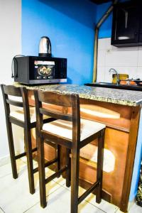 a kitchen counter with two chairs and a microwave at 6 Appartements/ 6 studios privé à Bangui RESIDENCE RENESSIOT in Bangui