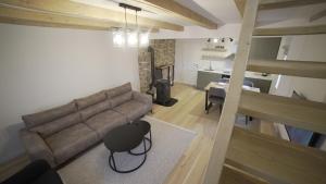 een woonkamer met een bruine bank en een keuken bij Apartman Trebevic-Sarajevo in Dovlići