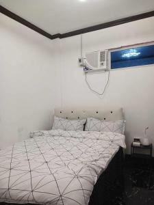 EJ'S House/ Room في Dulag: غرفة نوم بسرير ومكيف