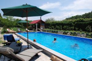 IslazにあるVilla Giuliaの水の中に人がいて傘もあるプール